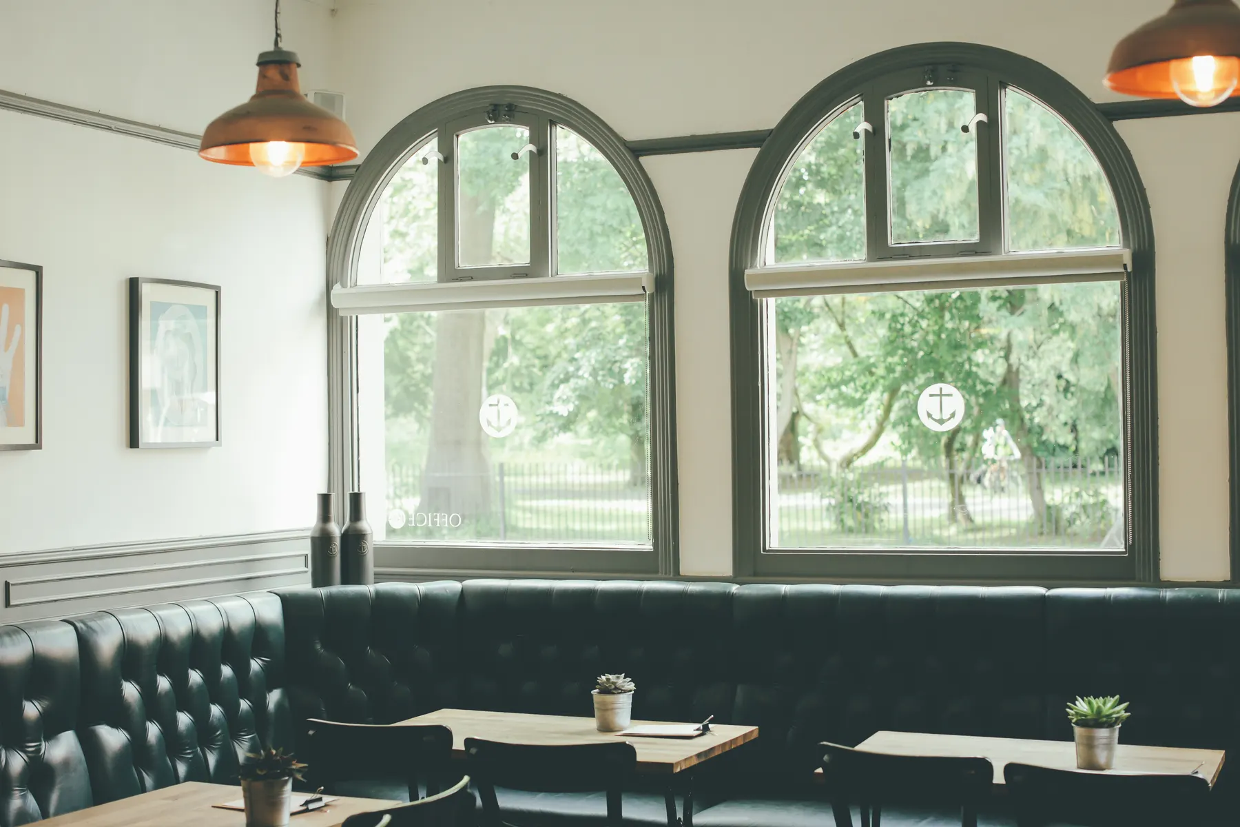 Bakery seating room with tall arched windows and copper pendant lamps