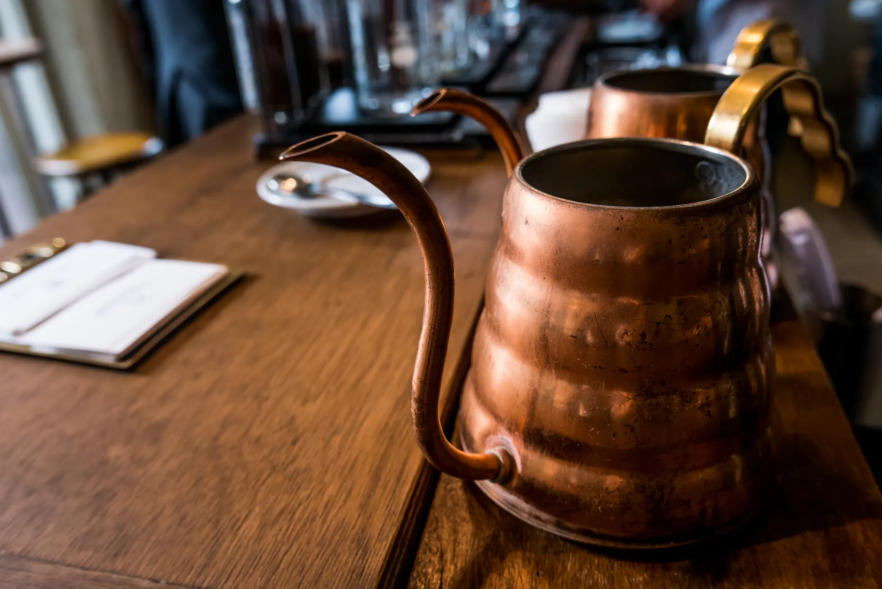 Polished copper kettle sitting on a wooden counter