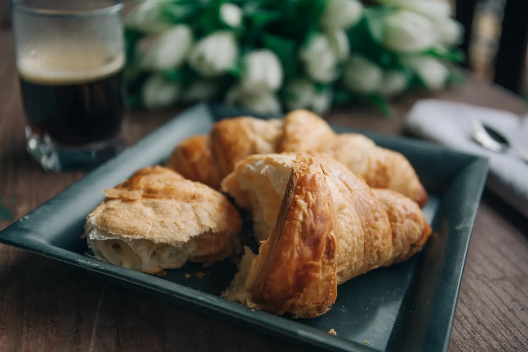 Tray of freshly baked croissants cooling on a baking sheet